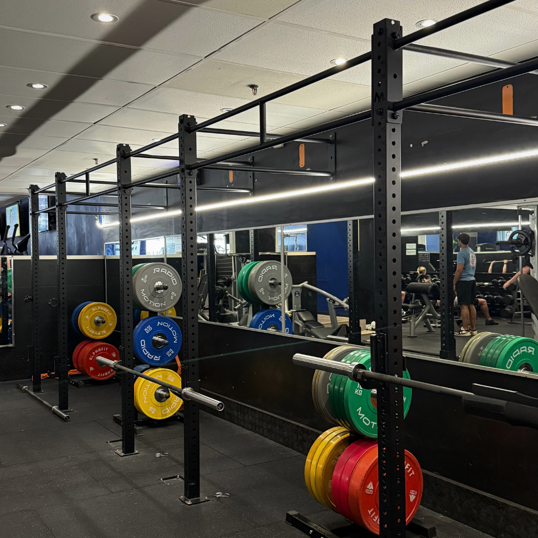 Weightlifting equipment and colorful plates in a gym setting.