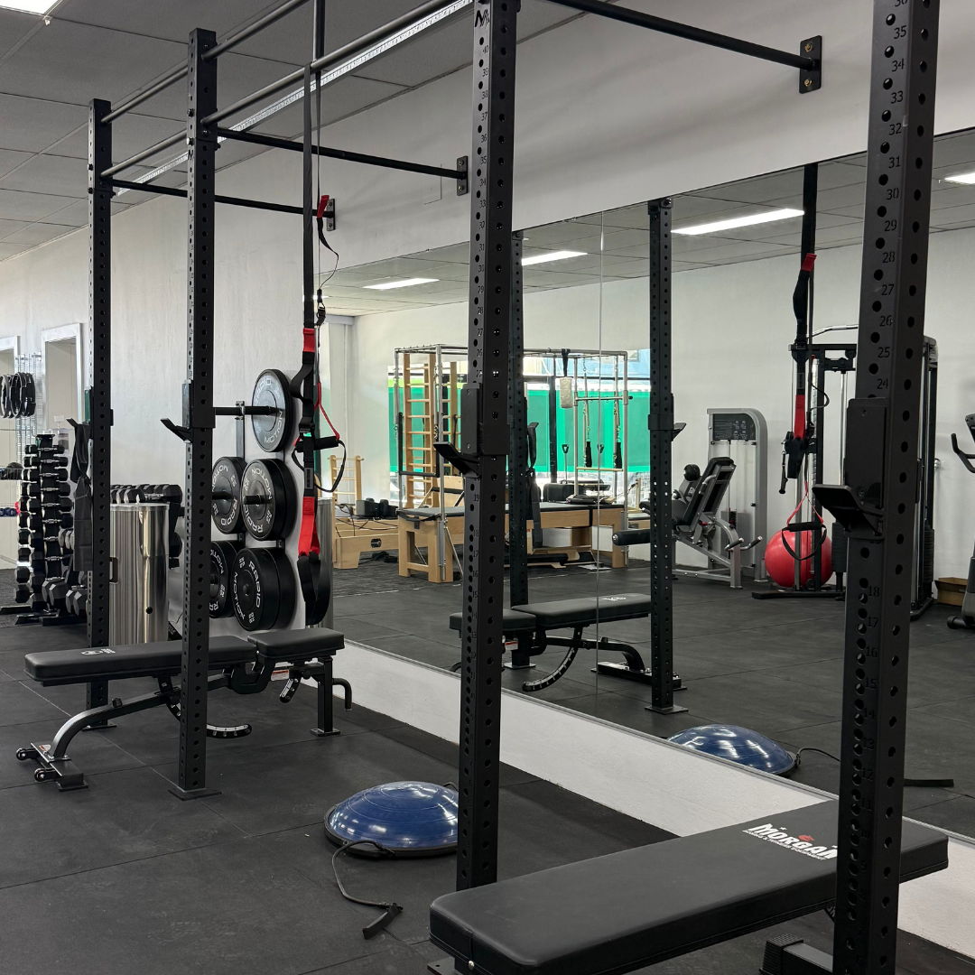 A gym interior with workout equipment and mirrors.