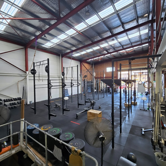 Interior of a gym with workout equipment and open space for exercises.